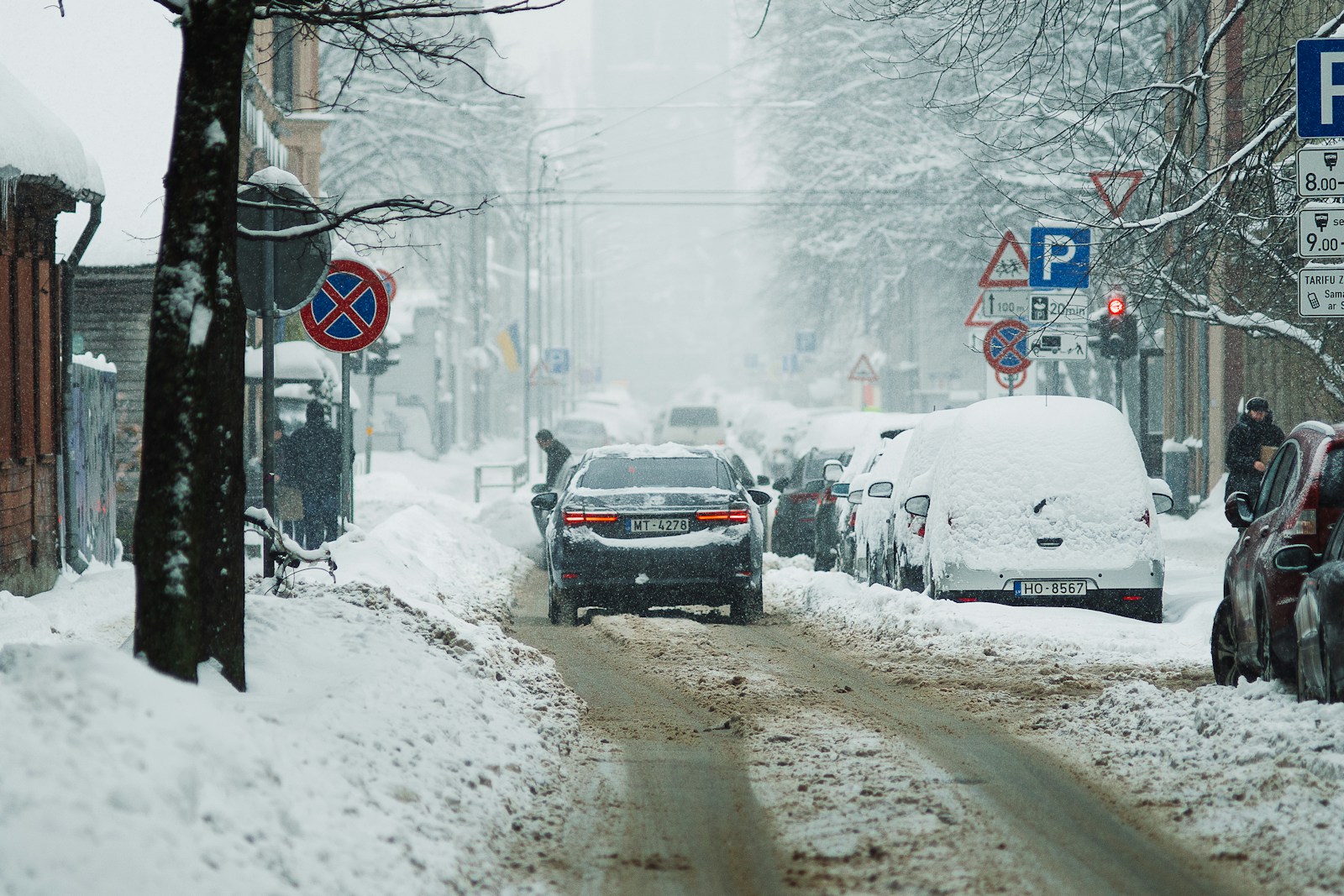 a car driving down a snow covered street