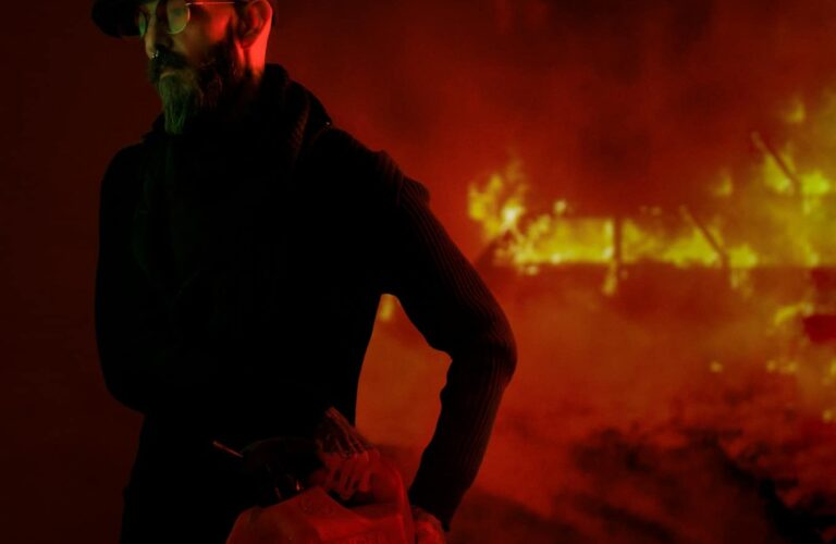 a man standing in front of a fire