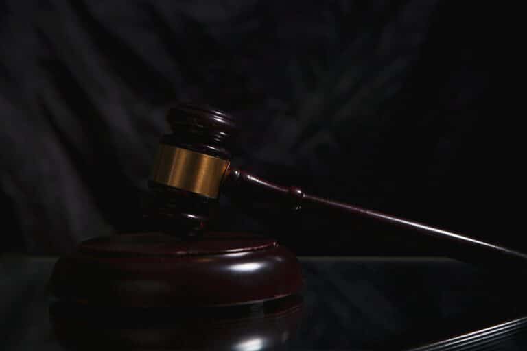 A wooden gavel rests on a dark surface.
