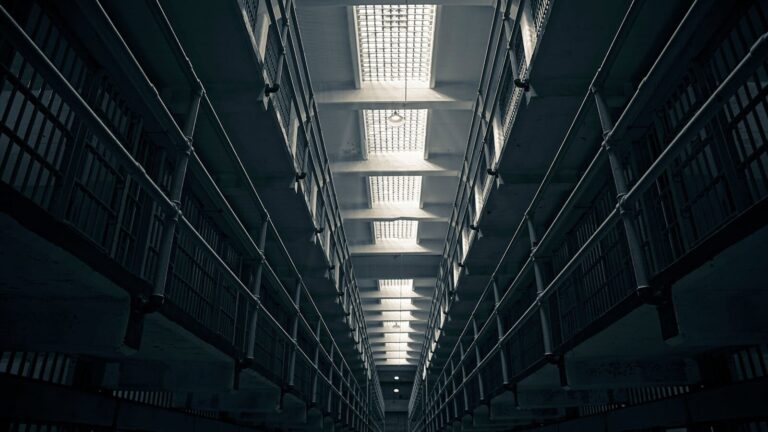 A low-angle view of Alcatraz prison cell block, showcasing steel railings.