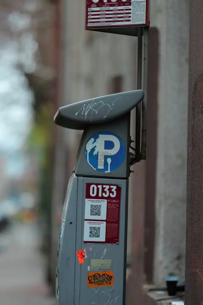 A parking meter with qr codes and graffiti.
