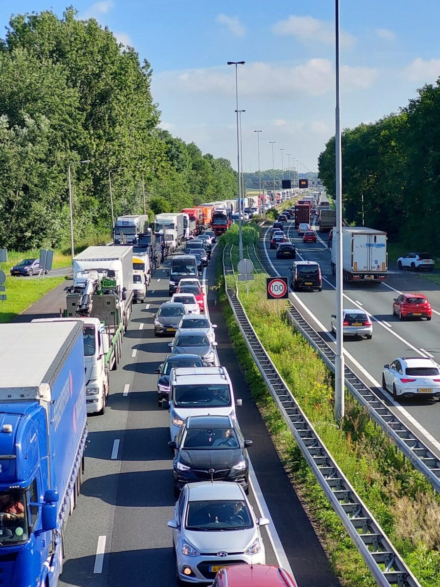 A highway filled with lots of traffic next to trees