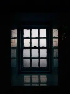 a window in a dark room with light coming through