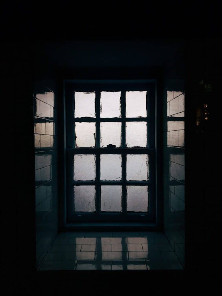 a window in a dark room with light coming through