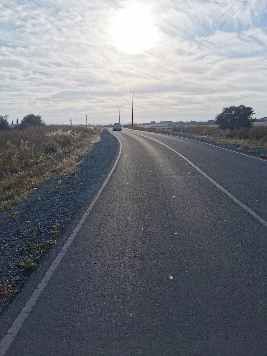 a truck is driving down the road in the middle of the day