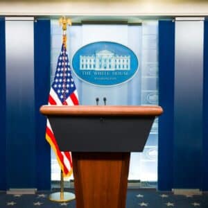 a podium with an american flag and the white house