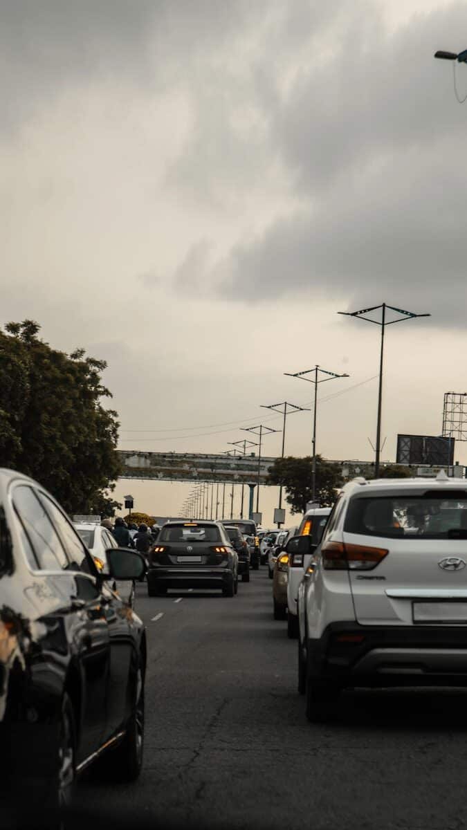 a street filled with lots of traffic under a cloudy sky