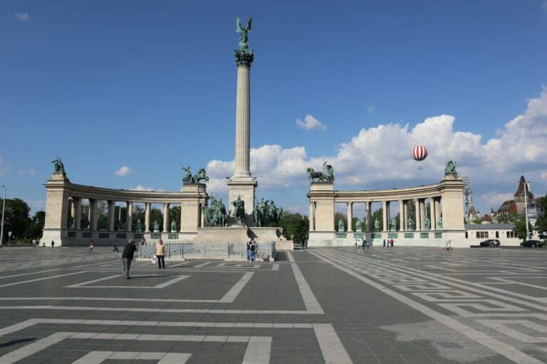A group of people standing in a parking lot next to a monument