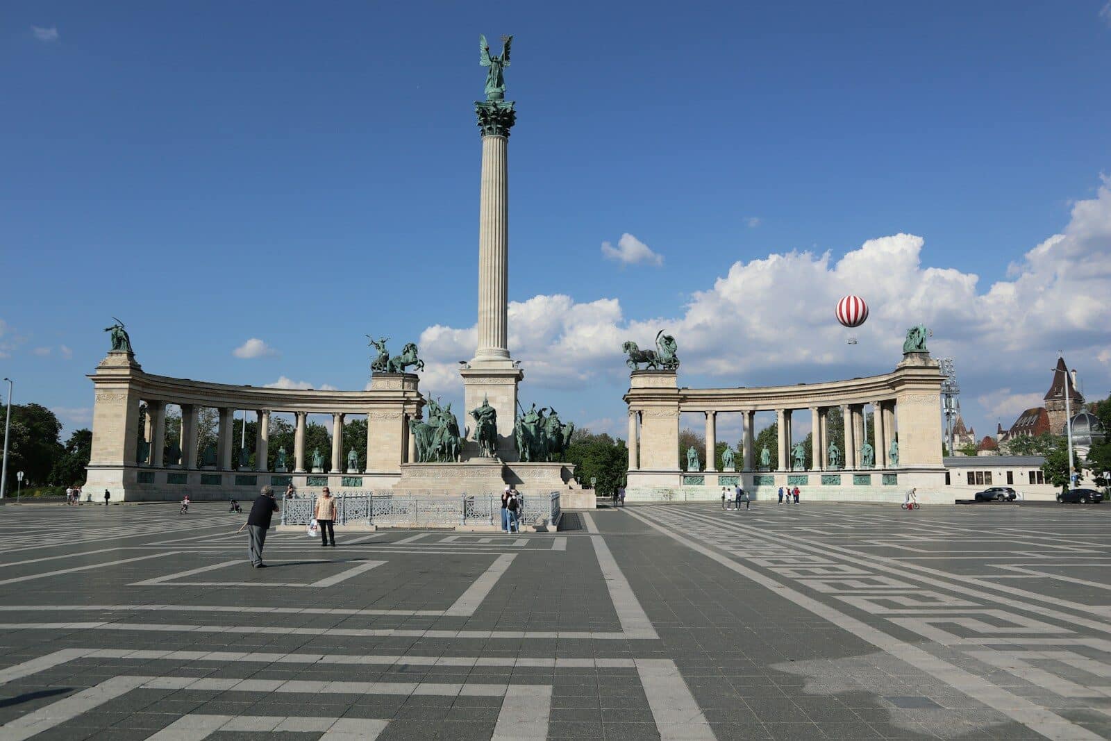 A group of people standing in a parking lot next to a monument