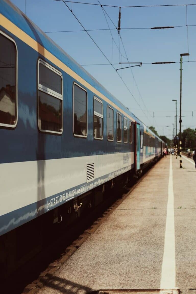 a blue and white train traveling down train tracks