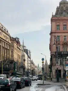 a city street filled with lots of traffic next to tall buildings