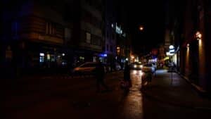 a couple of people walking down a street at night