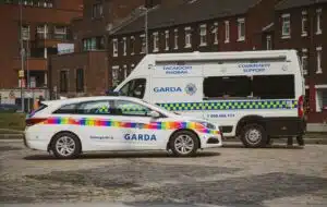 white and blue police van parked beside brown concrete building during daytime