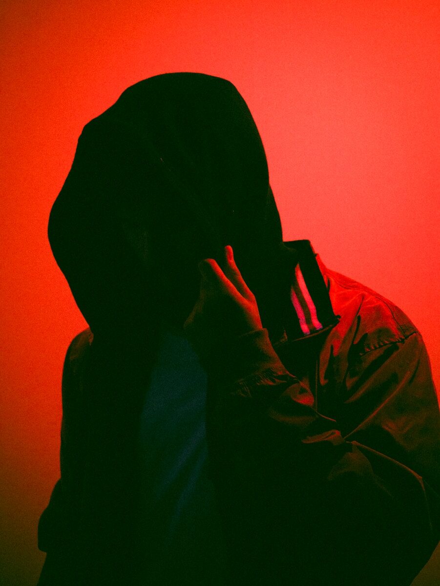 a person in a hooded jacket with a red background