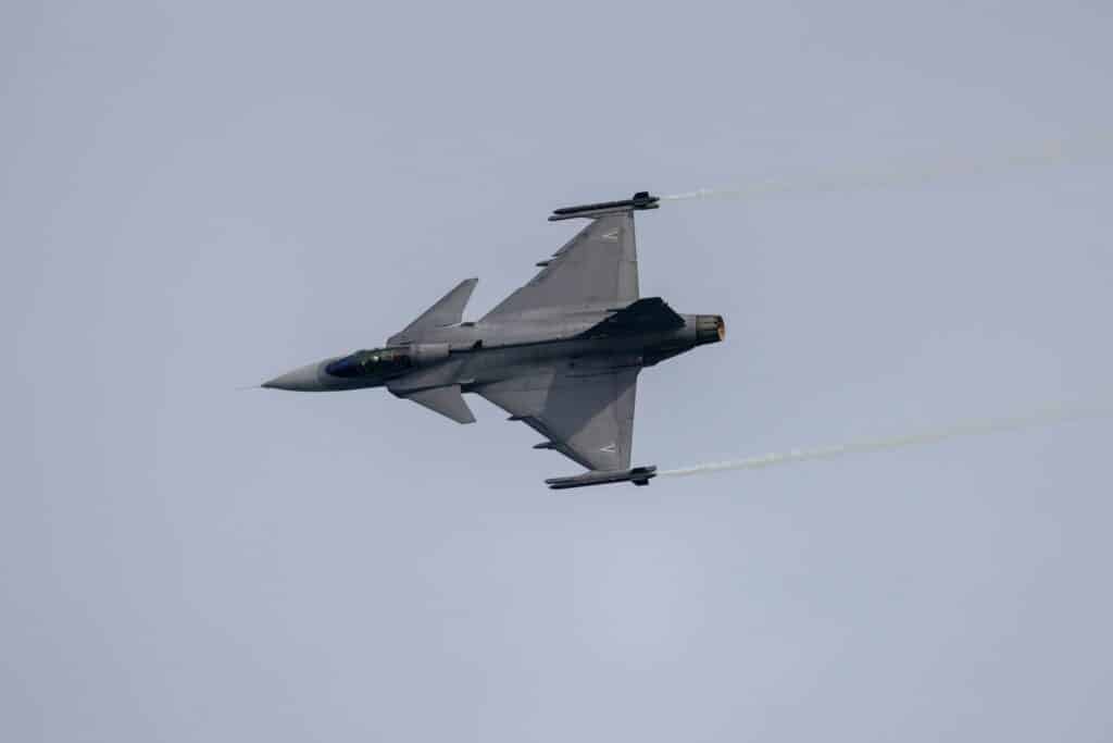 a fighter jet flying through a cloudy sky