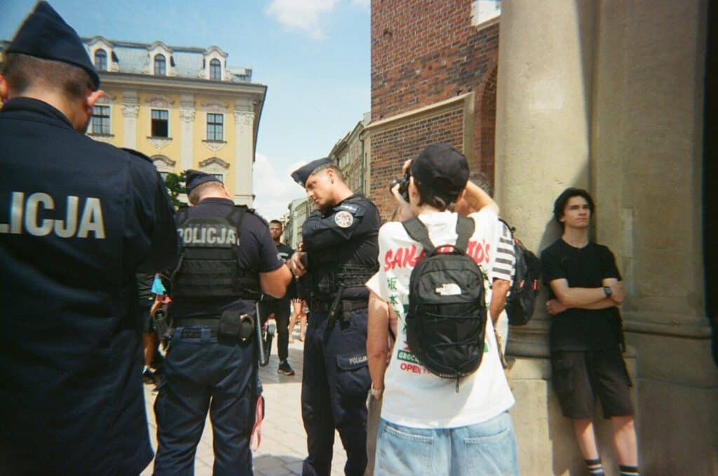Police officers stand near civilians on a street.