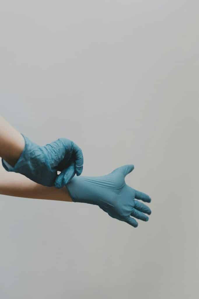 person putting on blue medical gloves
