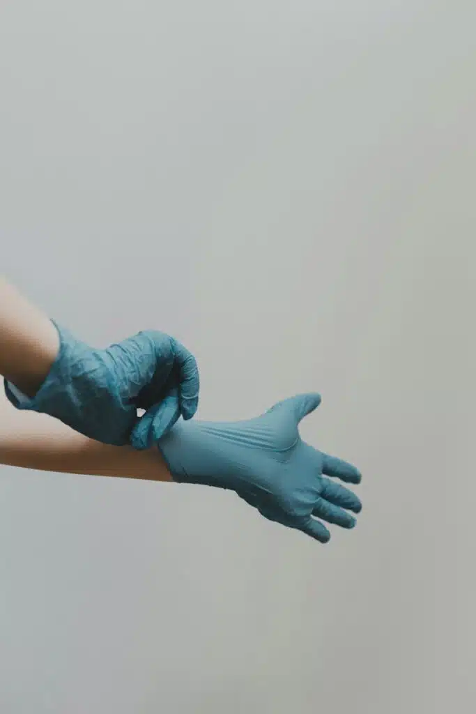 person putting on blue medical gloves