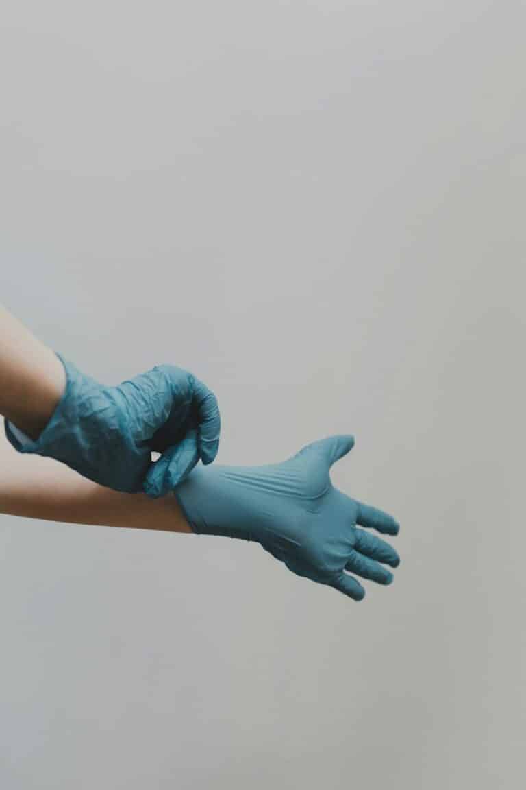 person putting on blue medical gloves