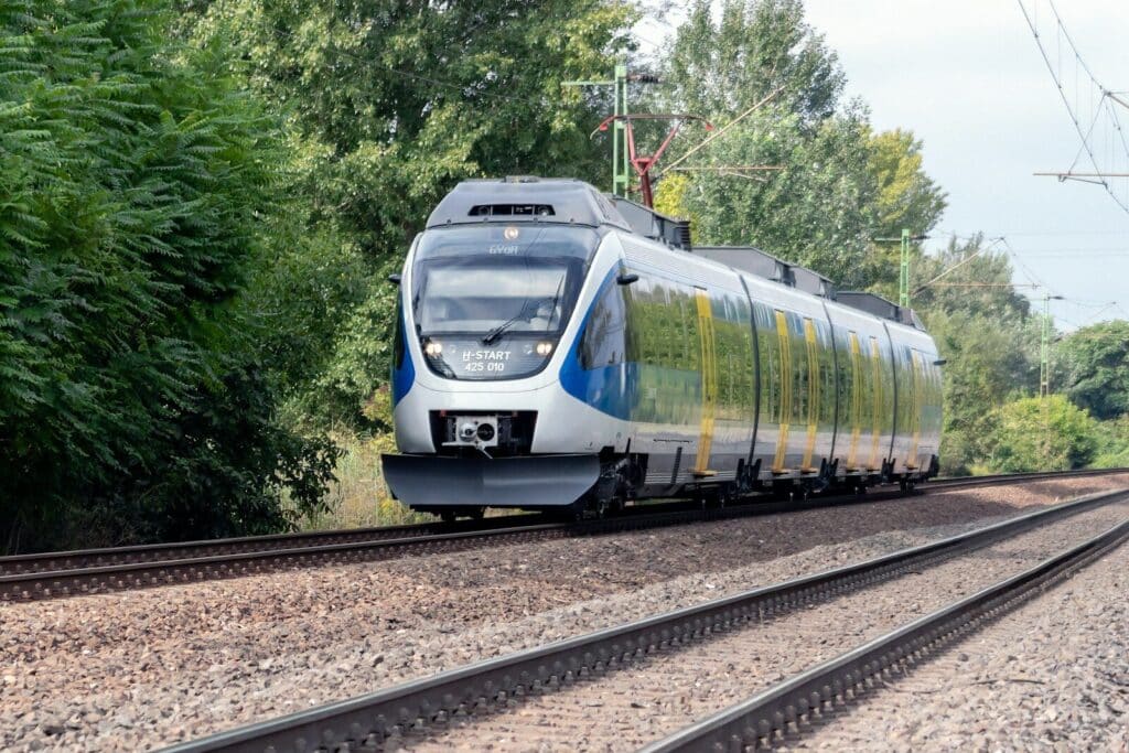 blue and white train on rail tracks during daytime