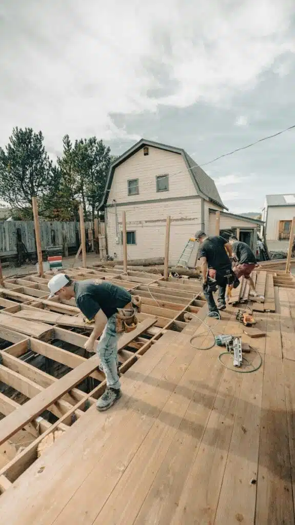 Construction workers building a wooden deck outdoors