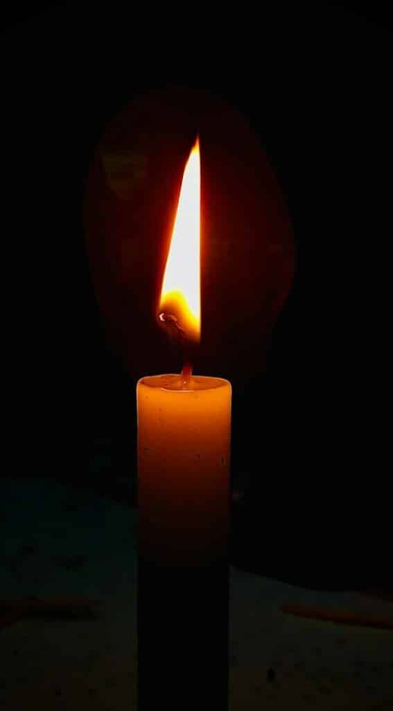 lighted candle in dark room