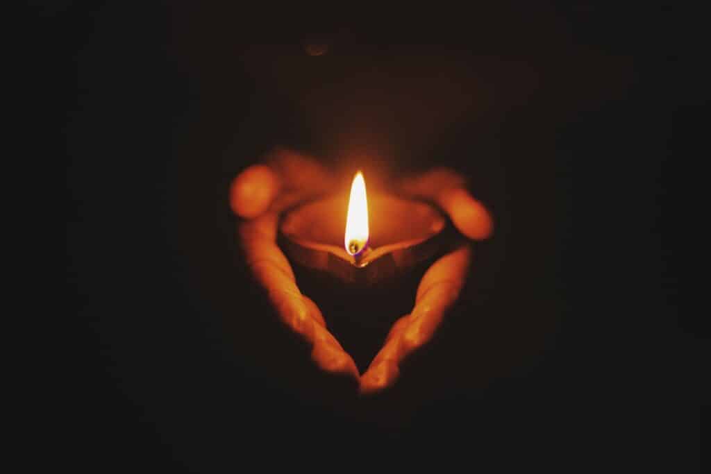 person holding lighted oil lamp